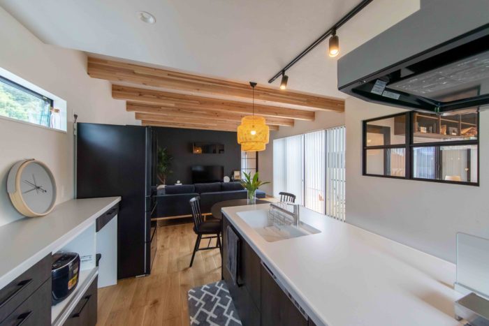 中庭付き平屋のLDK　キッチンからガラス窓（室内窓）を通してワークスペースが見える　飯田市下伊那郡の施工事例